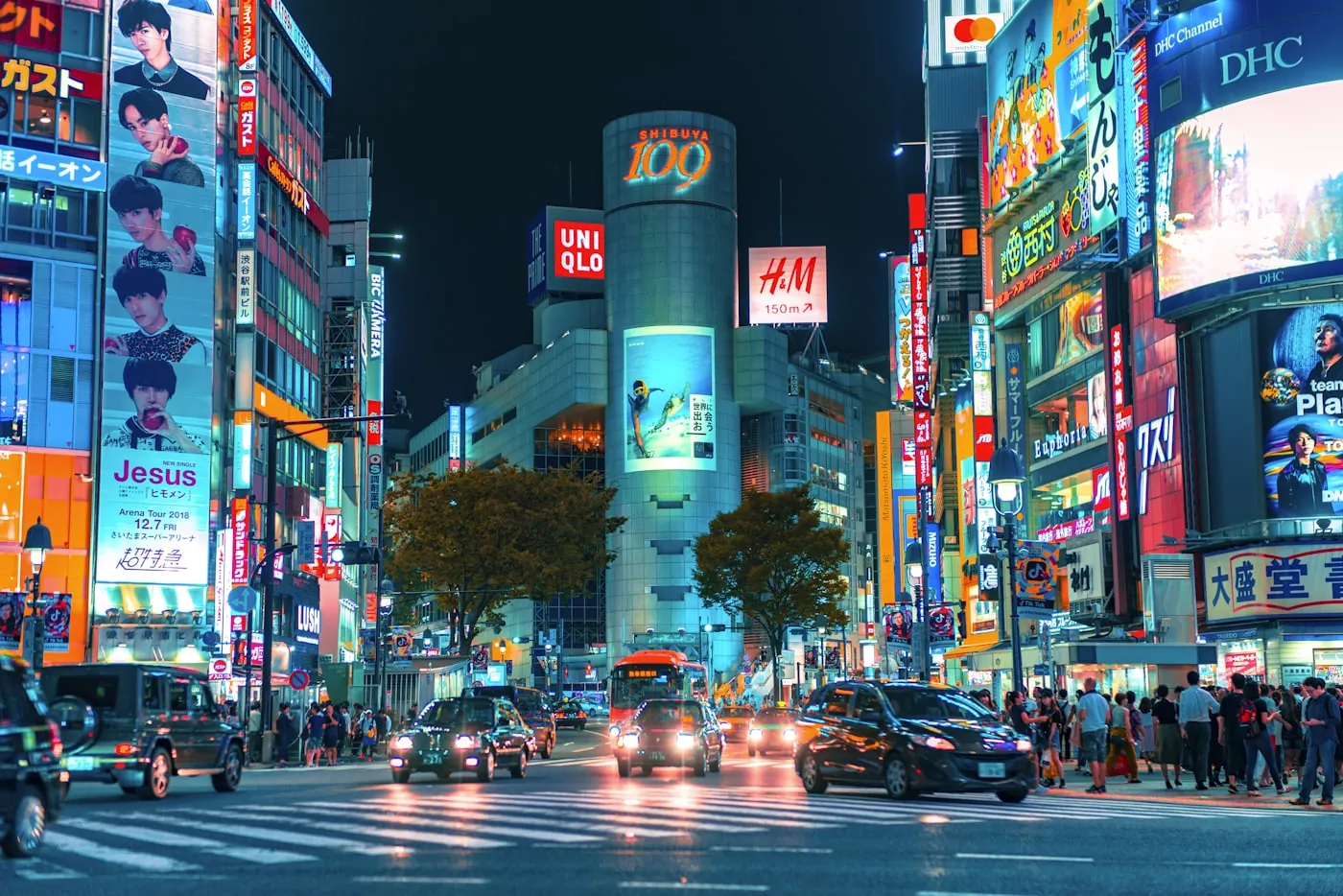 Neon storefronts and traffic in Shibuya, Tokyo, at night