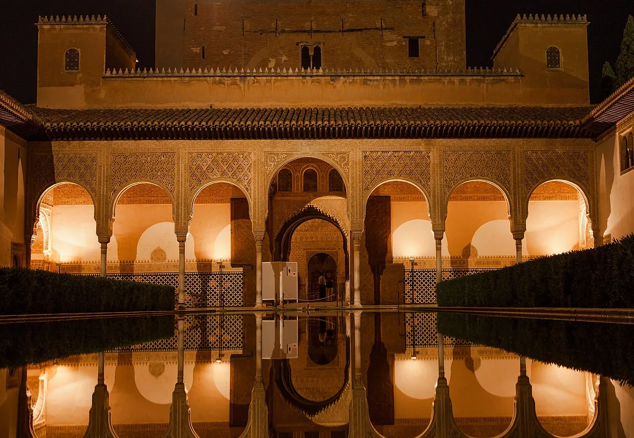 The Patio de los Arrayanes in the Alhambra at night, the Comares tower reflected in the long pool
