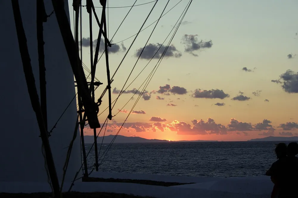 A Mykonos windmill silhouetted against the sunset