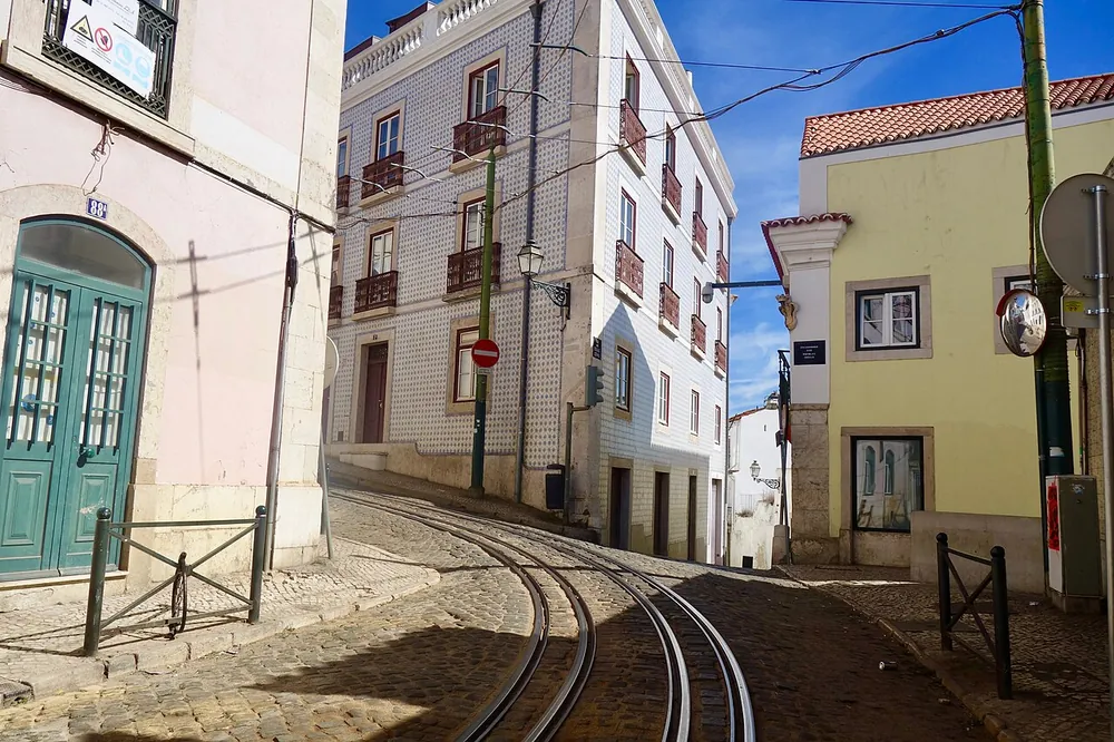 Tram tracks climbing a narrow street in Alfama, Lisbon