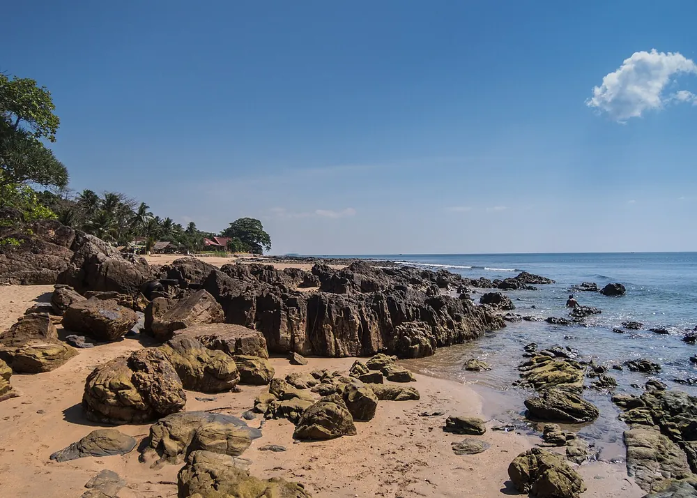 A rocky shoreline and empty beach on Koh Lanta